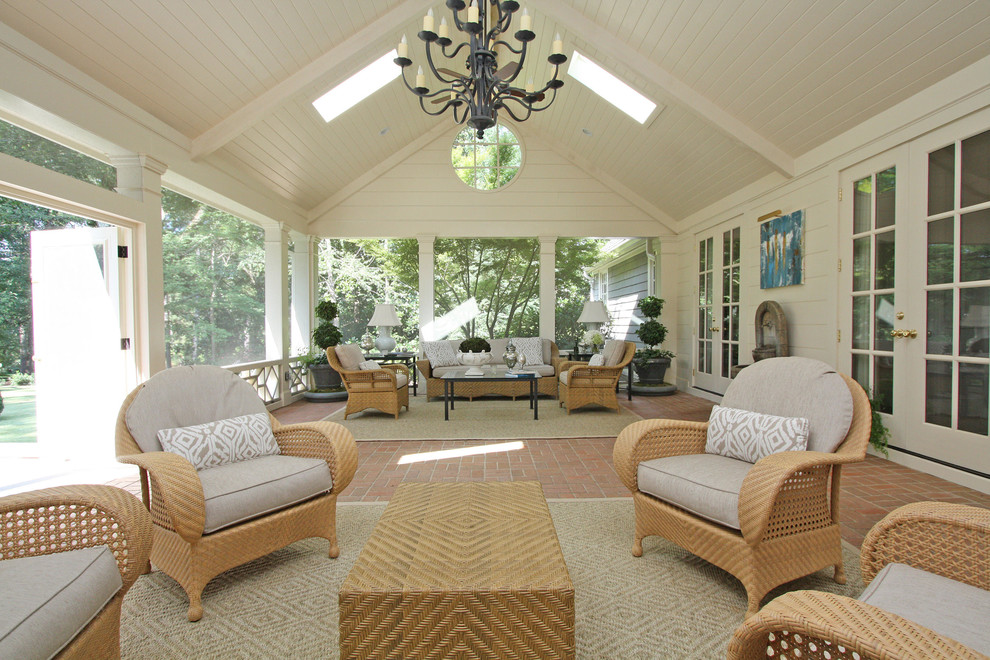 Inspiration for a large traditional verandah in Atlanta with with fireplace, brick pavers and a roof extension.
