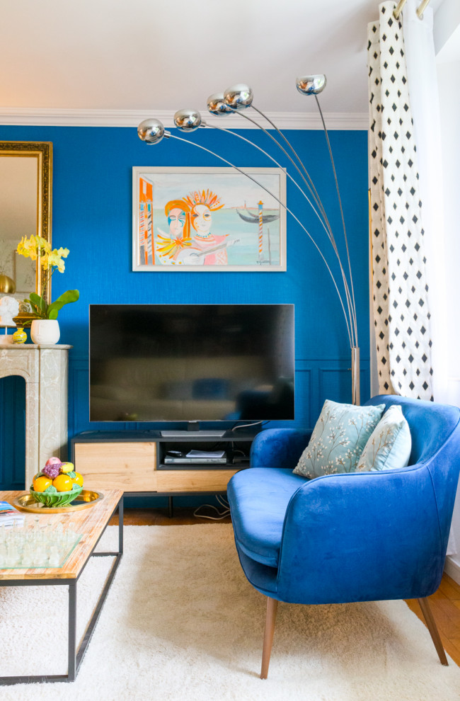 Photo of a large classic open plan games room in Other with blue walls, medium hardwood flooring, a standard fireplace, a freestanding tv, beige floors, wainscoting and feature lighting.