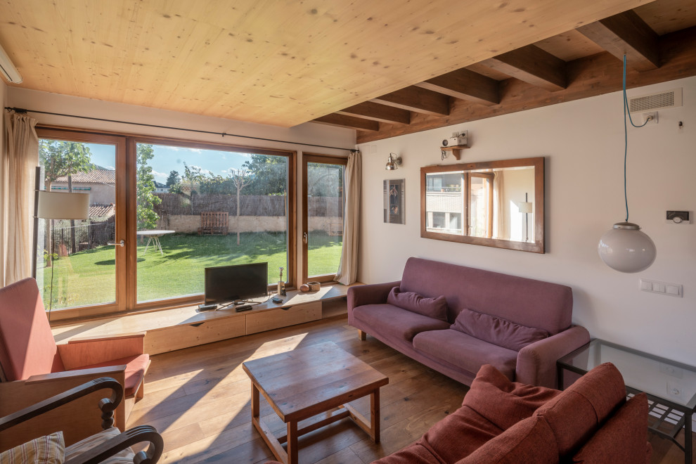 Ejemplo de sala de estar escandinava de tamaño medio con suelo de madera oscura y vigas vistas