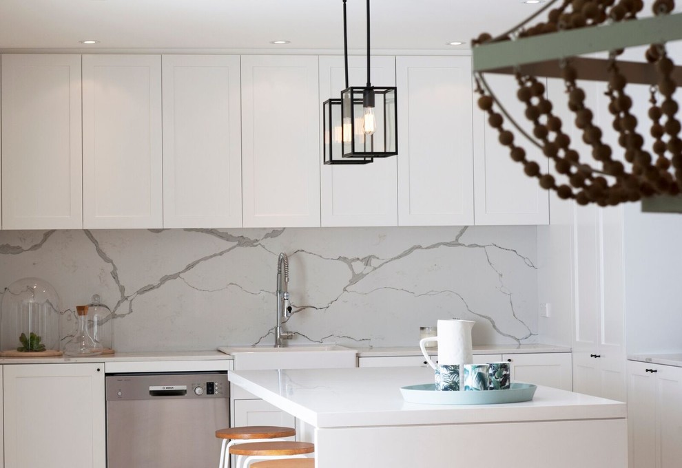 Inspiration for a large contemporary l-shaped eat-in kitchen in Sydney with a drop-in sink, quartz benchtops, white splashback, stone slab splashback, black appliances, light hardwood floors and with island.