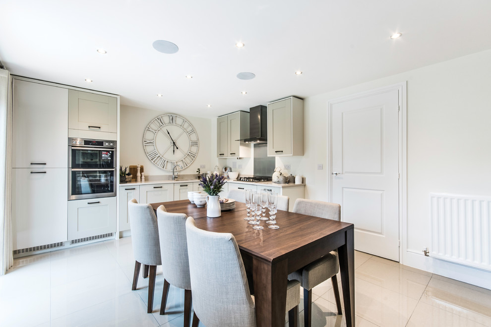 This is an example of a transitional l-shaped eat-in kitchen in Surrey with an undermount sink, shaker cabinets, grey cabinets, panelled appliances, no island, beige floor and white benchtop.