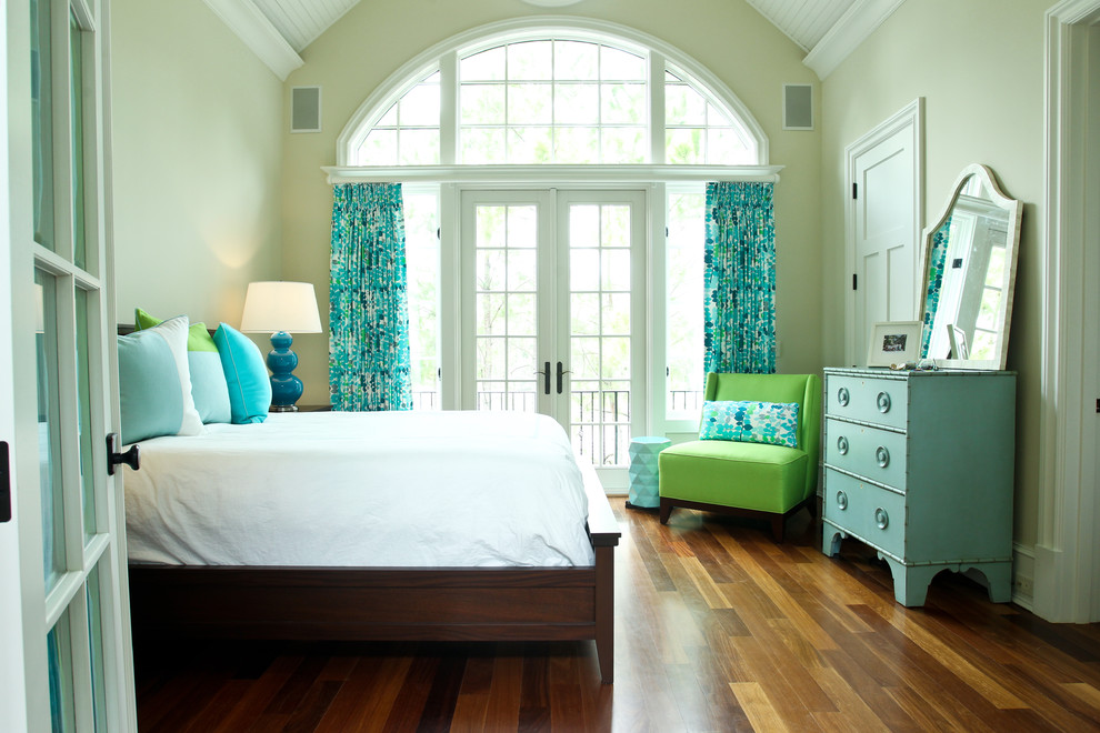 This is an example of a beach style bedroom in Charleston with beige walls and medium hardwood floors.
