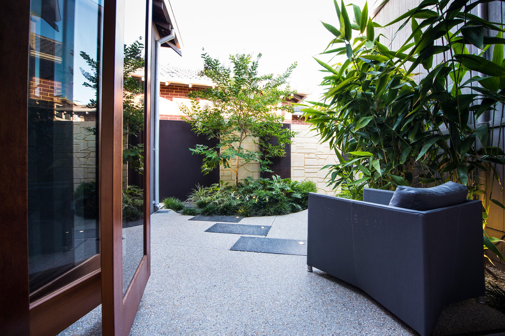 This is an example of a small contemporary courtyard patio in Perth with a water feature.