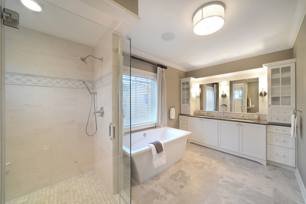 Large arts and crafts master bathroom in Boston with shaker cabinets, white cabinets, a freestanding tub, a corner shower, beige tile, limestone, beige walls, ceramic floors, an undermount sink, engineered quartz benchtops, beige floor and a hinged shower door.