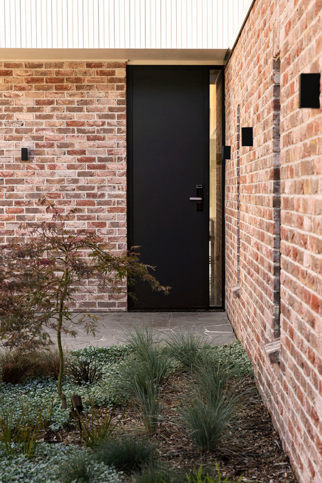 Mittelgroße Moderne Haustür mit weißer Wandfarbe, Betonboden, Einzeltür, schwarzer Haustür, grauem Boden, gewölbter Decke und Holzwänden in Auckland