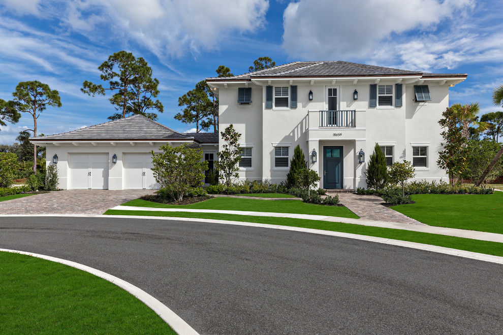 This is an example of a mid-sized beach style two-storey stucco white exterior in Miami with a hip roof.