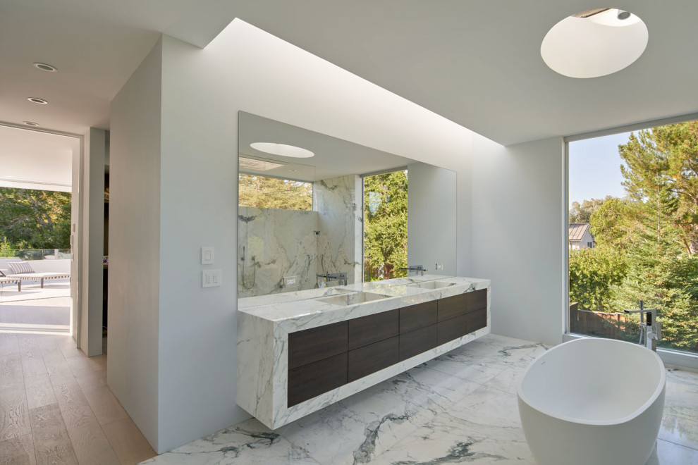 Design ideas for a large contemporary master bathroom in San Francisco with flat-panel cabinets, brown cabinets, a freestanding tub, an open shower, a wall-mount toilet, multi-coloured tile, marble, white walls, marble floors, an integrated sink, marble benchtops, white floor, an open shower, white benchtops, an enclosed toilet, a double vanity and a floating vanity.