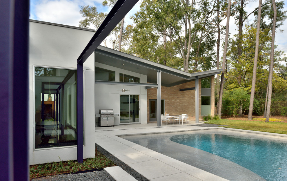 Contemporary rectangular pool in Houston with stamped concrete.