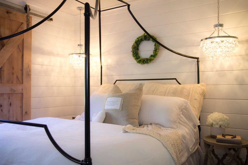 Bild på ett mellanstort lantligt sovrum, med vita väggar och mellanmörkt trägolv