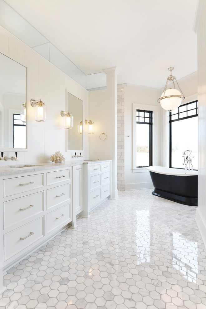 Example of a transitional white tile white floor freestanding bathtub design in Milwaukee with white cabinets, white walls and an undermount sink
