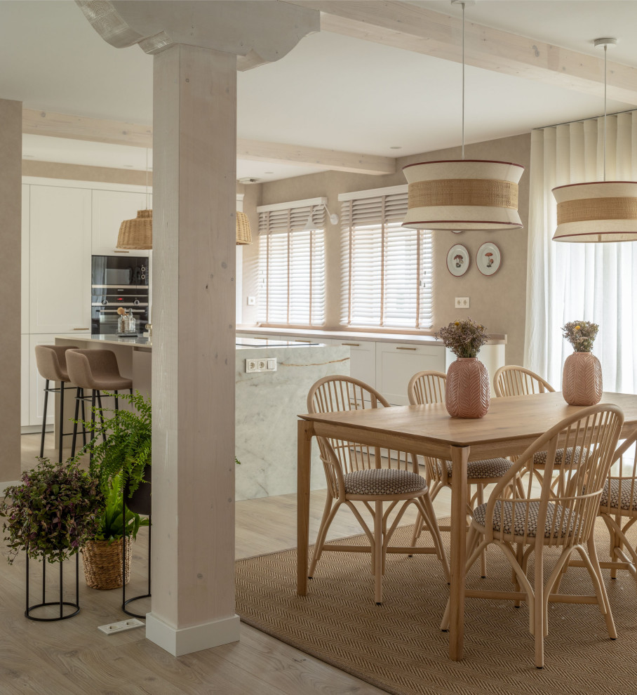 Ejemplo de comedor clásico renovado grande abierto con paredes beige, suelo laminado, todas las chimeneas, piedra de revestimiento, vigas vistas, papel pintado y cortinas