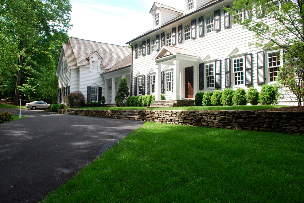Inspiration for a large traditional front yard partial sun driveway in DC Metro with a retaining wall.