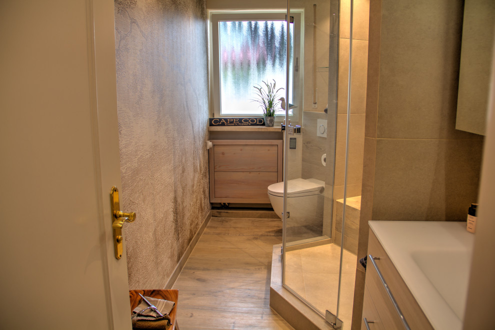 Пример оригинального дизайна: маленькая ванная комната в классическом стиле с плоскими фасадами, бежевыми фасадами, душем без бортиков, раздельным унитазом, бежевой плиткой, плиткой под дерево, бежевыми стенами, полом из плитки под дерево, душевой кабиной, монолитной раковиной, стеклянной столешницей, коричневым полом, душем с распашными дверями, белой столешницей, сиденьем для душа, тумбой под одну раковину, подвесной тумбой, многоуровневым потолком и обоями на стенах для на участке и в саду