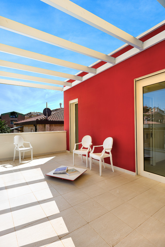 This is an example of a large beach style balcony in Florence with a pergola.