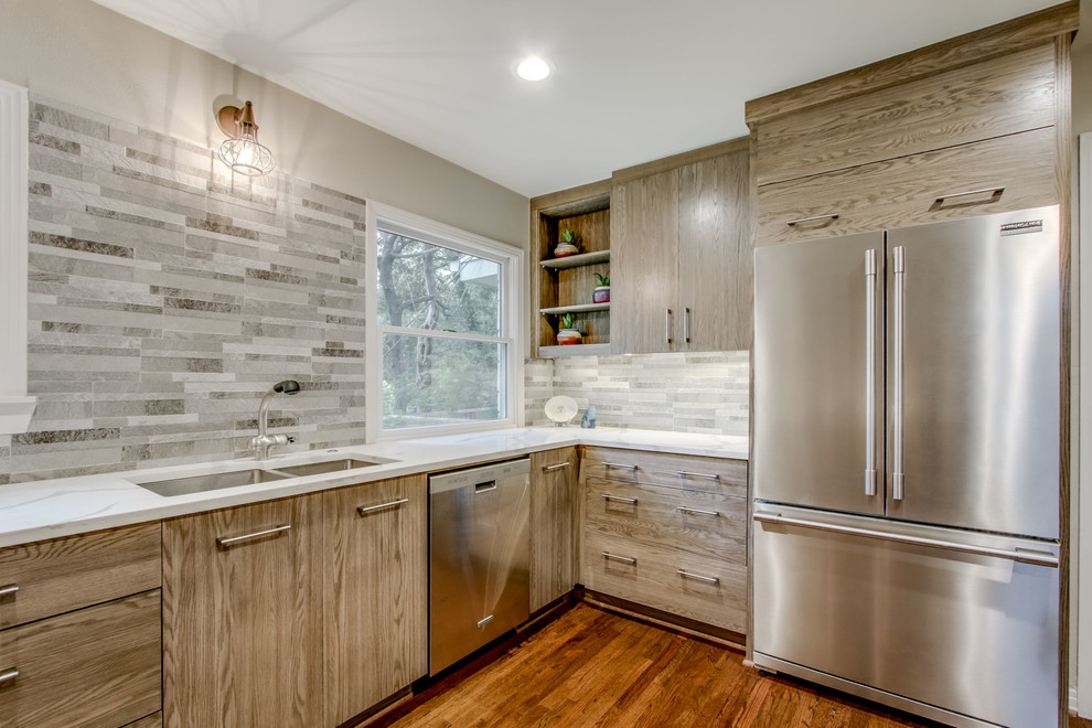 Photo of a mid-sized transitional u-shaped separate kitchen in Dallas with an undermount sink, flat-panel cabinets, distressed cabinets, quartz benchtops, grey splashback, porcelain splashback, stainless steel appliances, medium hardwood floors, brown floor and white benchtop.