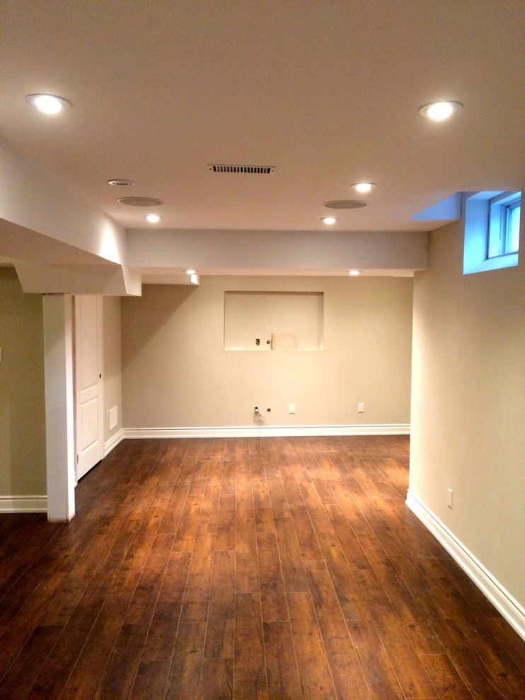 Inspiration for a mid-sized traditional fully buried basement in Toronto with dark hardwood floors and beige walls.