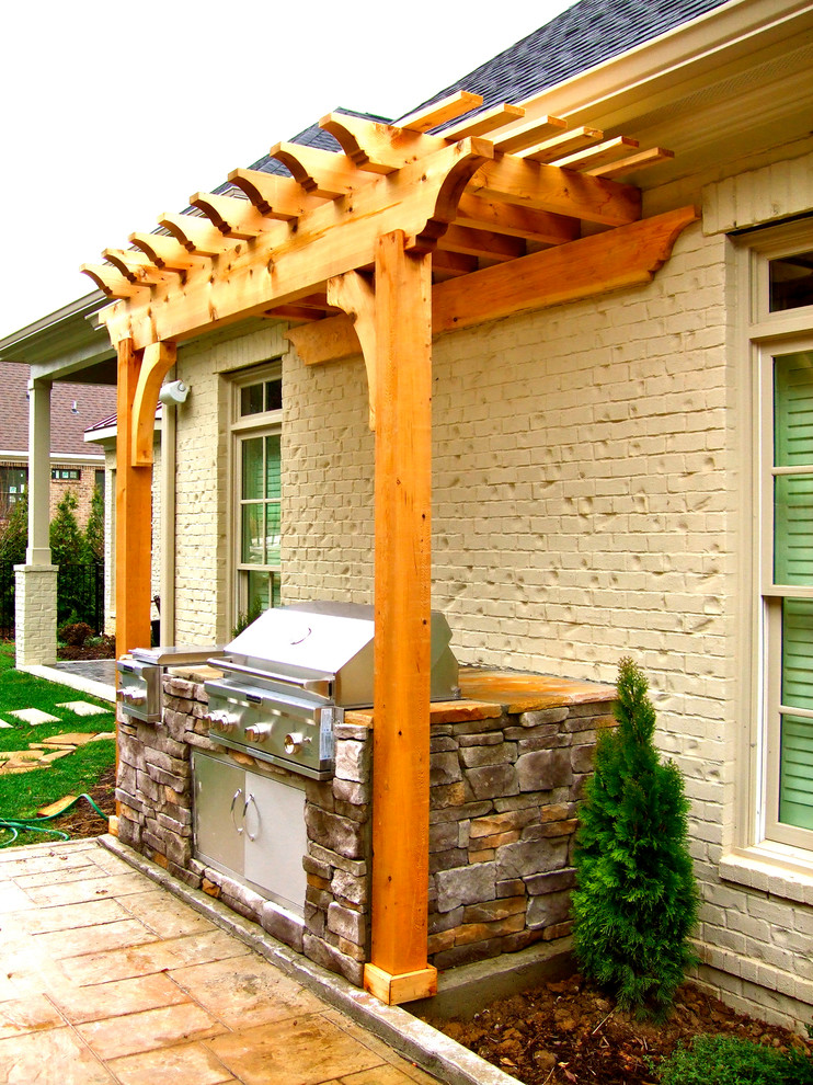 Inspiration for a small country backyard patio in Nashville with an outdoor kitchen, stamped concrete and a pergola.