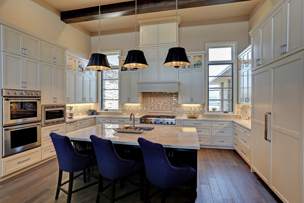 Example of a large transitional u-shaped light wood floor, gray floor and exposed beam enclosed kitchen design in San Diego with an undermount sink, shaker cabinets, white cabinets, marble countertops, beige backsplash, mosaic tile backsplash, stainless steel appliances, an island and white countertops