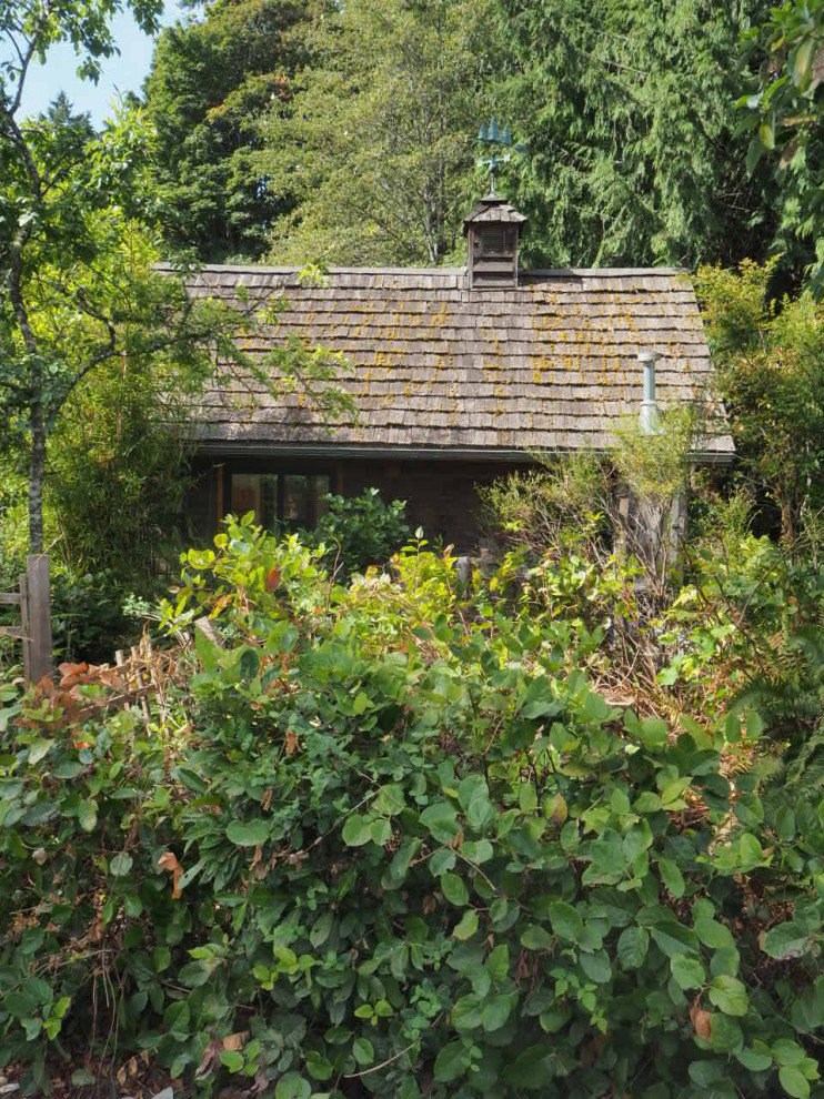 Идея дизайна: маленький, одноэтажный, деревянный, коричневый мини дом в стиле рустика с двускатной крышей, крышей из гибкой черепицы, коричневой крышей и отделкой планкеном для на участке и в саду