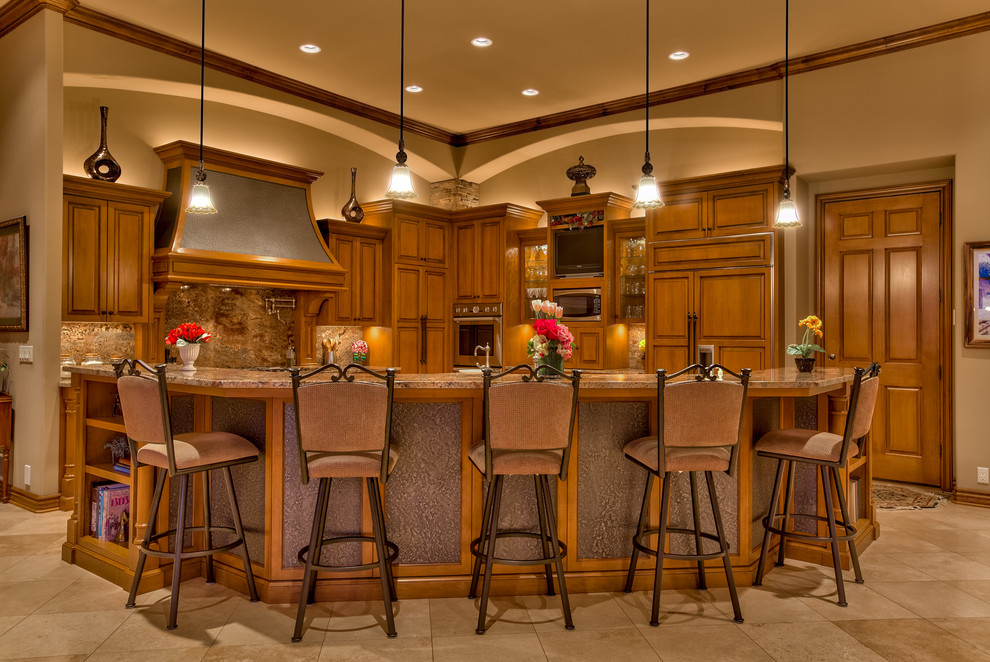 Large traditional l-shaped eat-in kitchen in Omaha with recessed-panel cabinets, medium wood cabinets, granite benchtops, brown splashback, stone slab splashback, stainless steel appliances, porcelain floors, an undermount sink, multiple islands and beige floor.