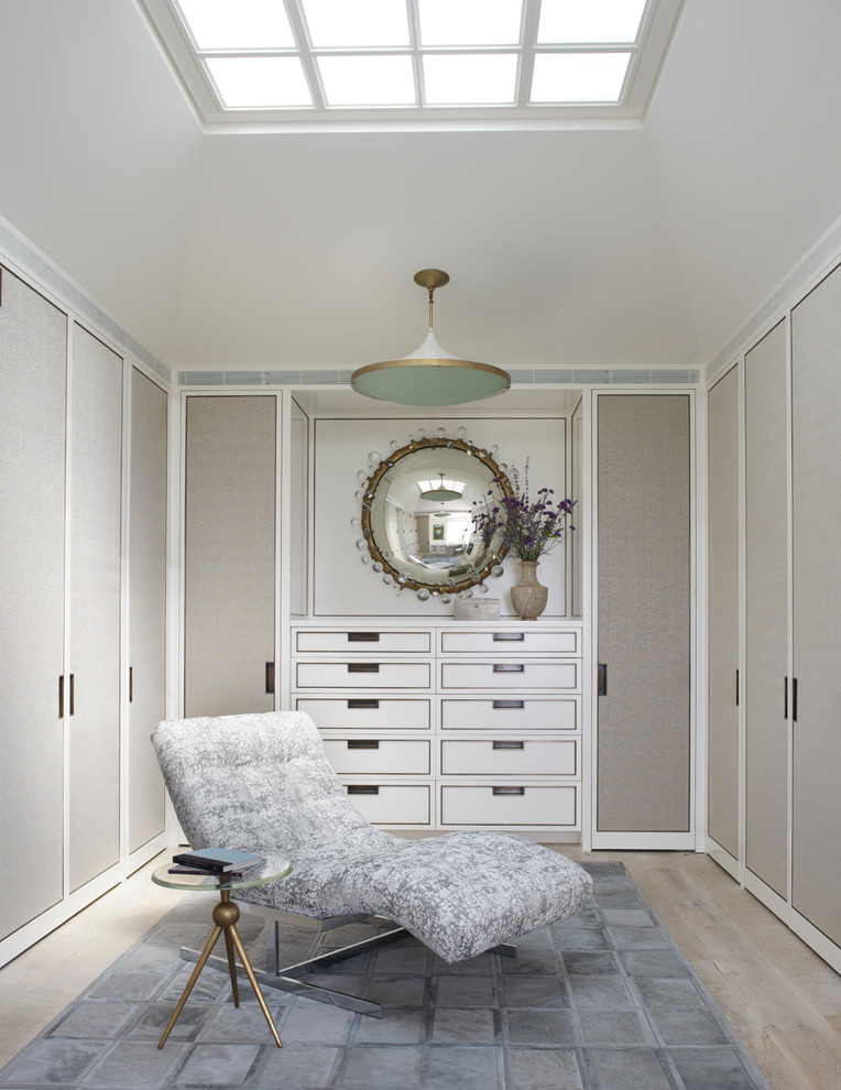 Design ideas for a contemporary women's dressing room in New York with flat-panel cabinets, grey cabinets, light hardwood floors and grey floor.