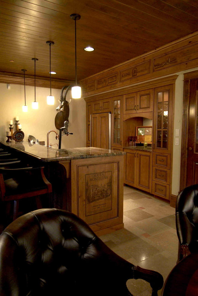 Photo of a large country seated home bar in Other with recessed-panel cabinets, distressed cabinets, granite benchtops and travertine floors.