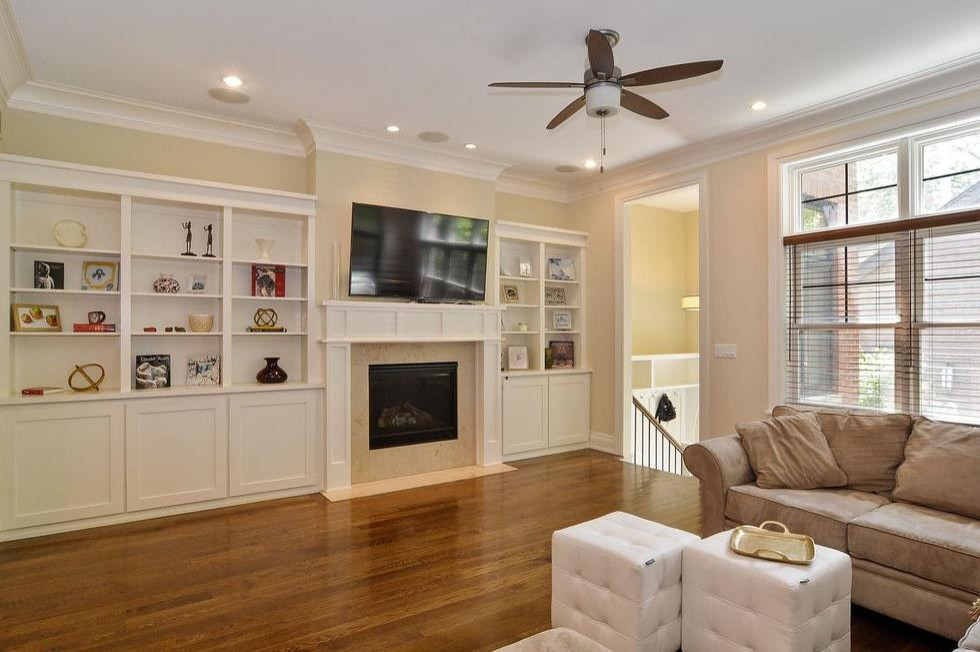 Großes, Offenes Klassisches Wohnzimmer mit beiger Wandfarbe, braunem Holzboden, Kamin, TV-Wand und braunem Boden in Chicago