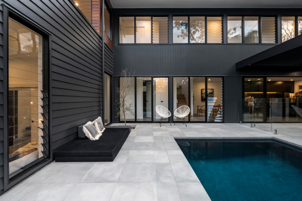 Inspiration for a contemporary side yard lap pool with tile.