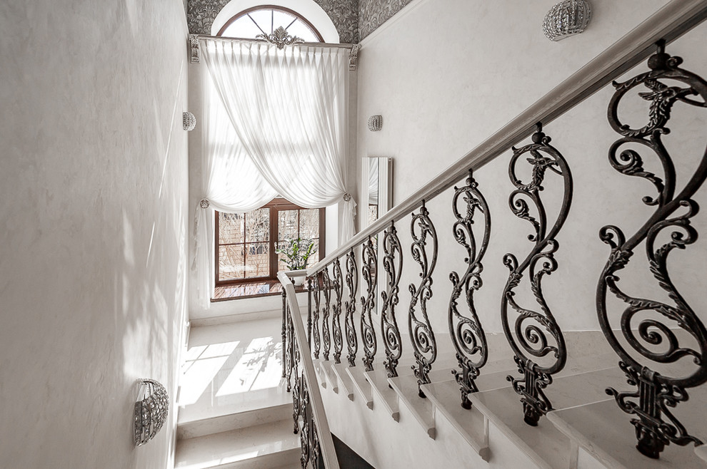 Mid-sized traditional marble u-shaped staircase in Other with marble risers and mixed railing.
