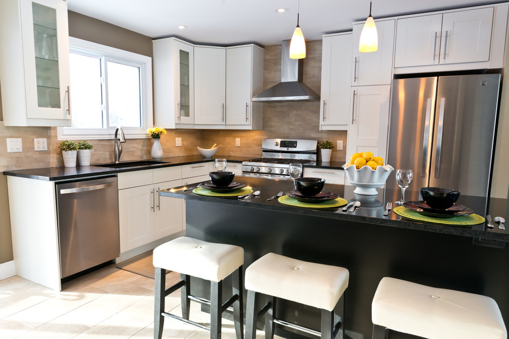 Inspiration for a kitchen remodel in Ottawa with an undermount sink, white cabinets, beige backsplash, mosaic tile backsplash, stainless steel appliances and an island