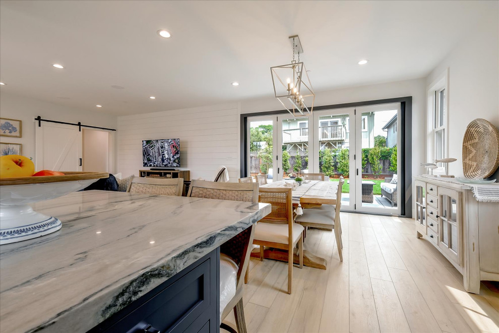 Mid-sized beach style l-shaped vinyl floor and beige floor eat-in kitchen photo in San Francisco with a farmhouse sink, beaded inset cabinets, white cabinets, quartzite countertops, white backsplash, ceramic backsplash, stainless steel appliances, an island and gray countertops
