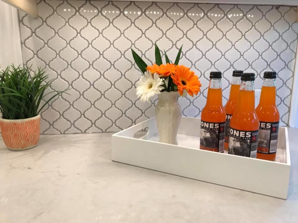 Eat-in kitchen - transitional u-shaped medium tone wood floor eat-in kitchen idea in Toronto with an undermount sink, raised-panel cabinets, white cabinets, quartz countertops, white backsplash, porcelain backsplash, stainless steel appliances, no island and white countertops