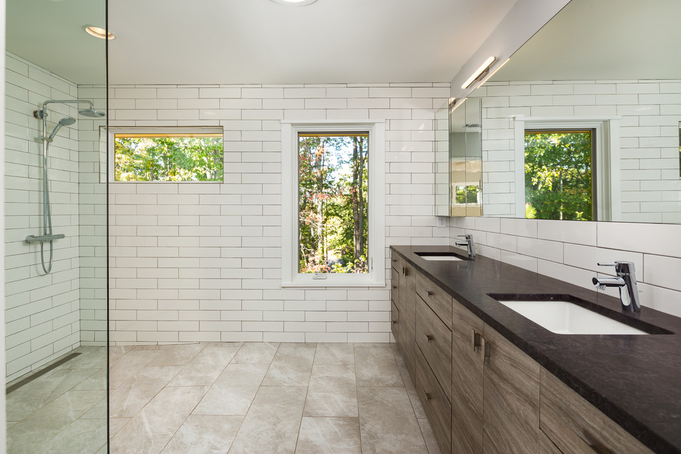 Photo of a large modern master bathroom in Atlanta with flat-panel cabinets, dark wood cabinets, an open shower, a one-piece toilet, white tile, porcelain tile, grey walls, porcelain floors, an undermount sink and soapstone benchtops.