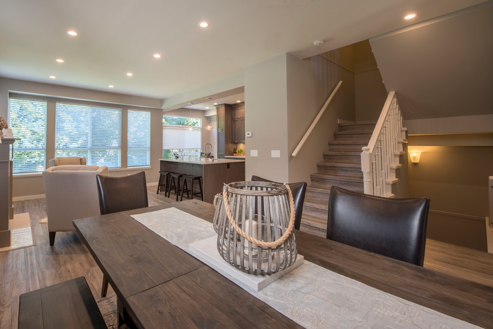 Photo of a small transitional open concept family room in Vancouver with beige walls, vinyl floors, a standard fireplace, a tile fireplace surround, no tv and brown floor.