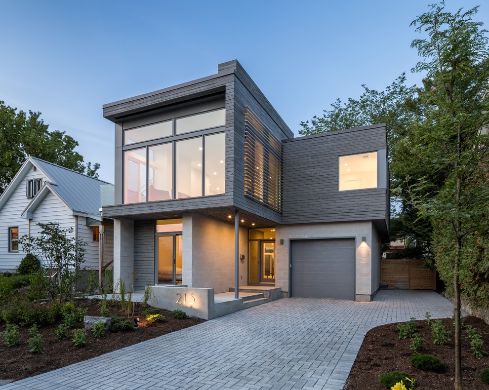 Photo of a large modern two-storey grey exterior in Ottawa with mixed siding and a flat roof.