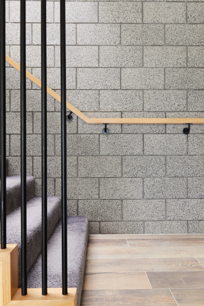 Diseño de escalera en L contemporánea de tamaño medio con escalones enmoquetados, contrahuellas enmoquetadas, barandilla de madera y ladrillo