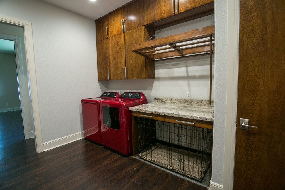 Photo of a large contemporary galley utility room in Houston with flat-panel cabinets, granite benchtops, grey walls, vinyl floors, a side-by-side washer and dryer and dark wood cabinets.