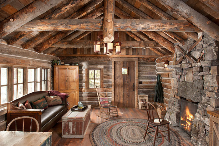 This is an example of a mid-sized country open concept living room in Other with brown walls, medium hardwood floors, a standard fireplace, a stone fireplace surround and no tv.