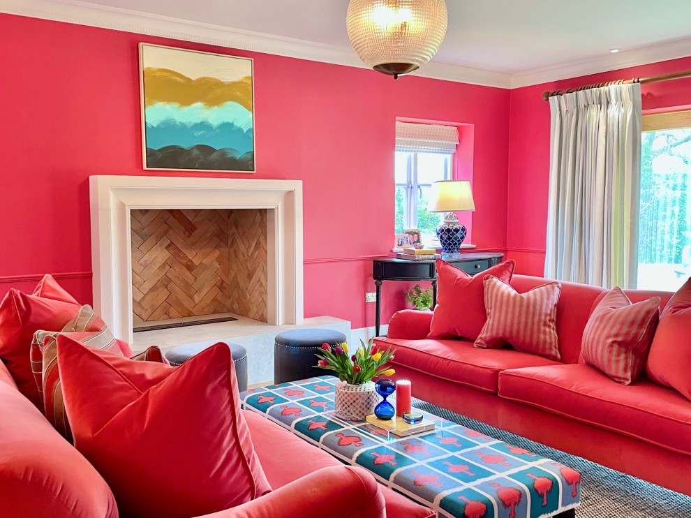 Foto di un soggiorno design con pareti rosse e camino classico