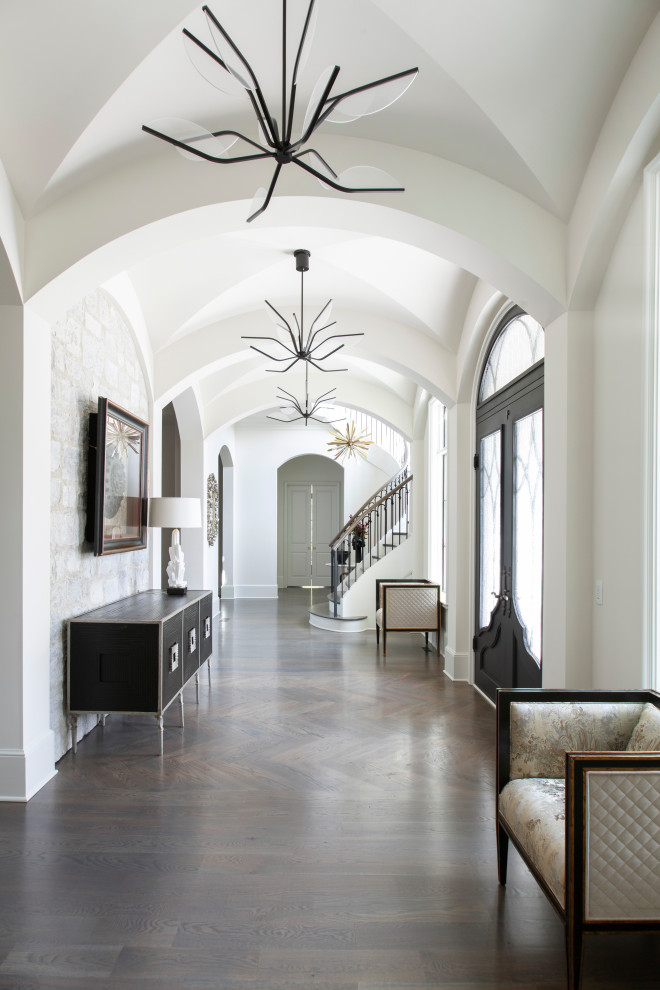 Mediterranean entry hall in Charlotte with white walls, dark hardwood floors and brown floor.