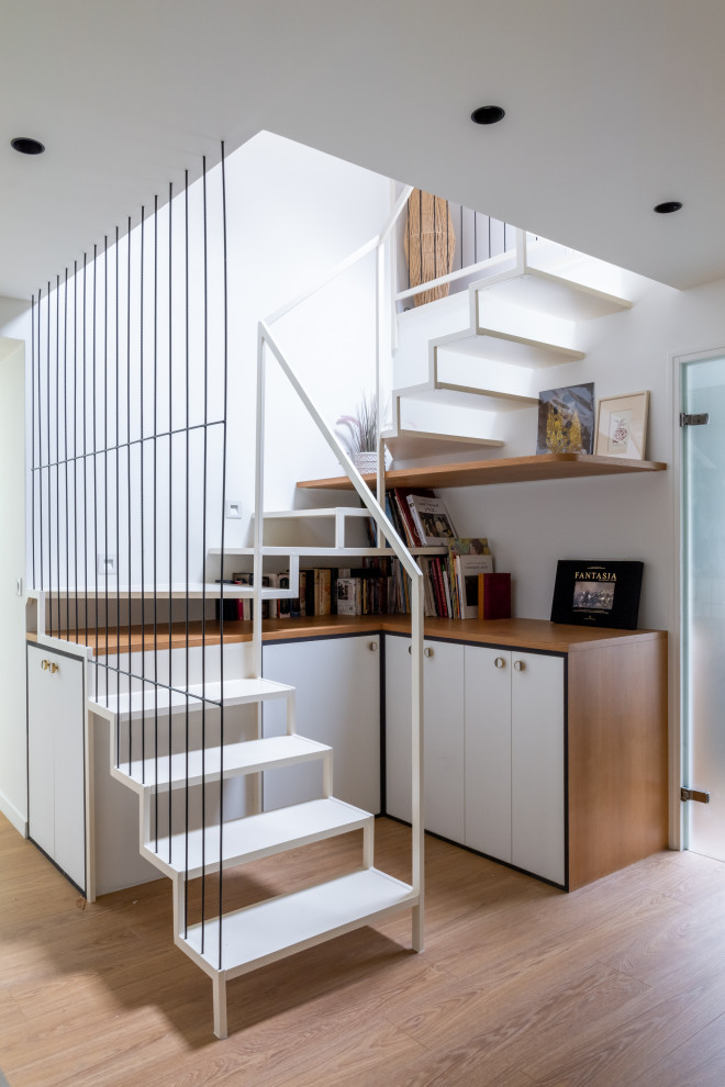 На фото: большая п-образная лестница в современном стиле с крашенными деревянными ступенями, металлическими перилами и кладовкой или шкафом под ней