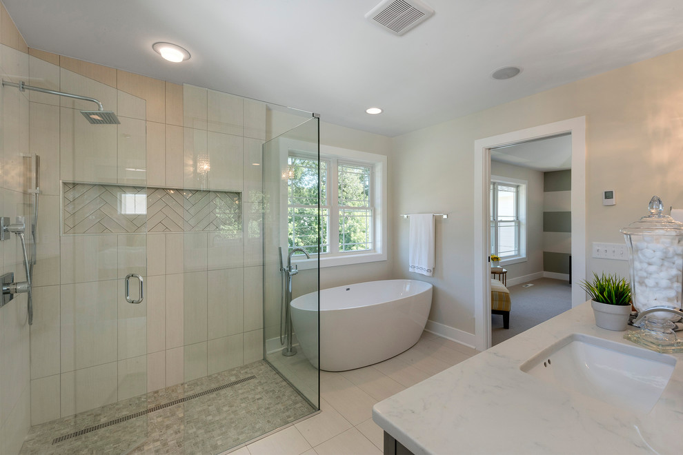 Inspiration for a large transitional master bathroom in Minneapolis with recessed-panel cabinets, grey cabinets, a freestanding tub, a corner shower, beige walls, an undermount sink, beige floor and a hinged shower door.