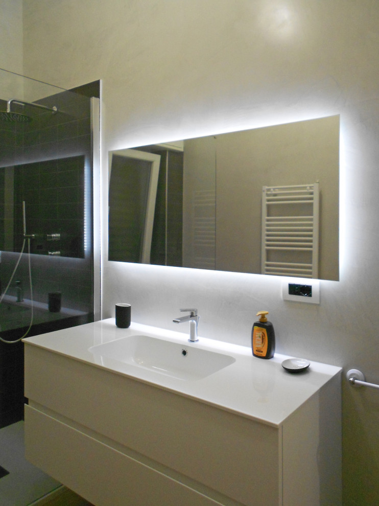 Mid-sized contemporary 3/4 bathroom in Other with flat-panel cabinets, white cabinets, an alcove shower, a one-piece toilet, black tile, grey walls, porcelain floors, an integrated sink, brown floor, an open shower, white benchtops, a niche, a single vanity and a floating vanity.