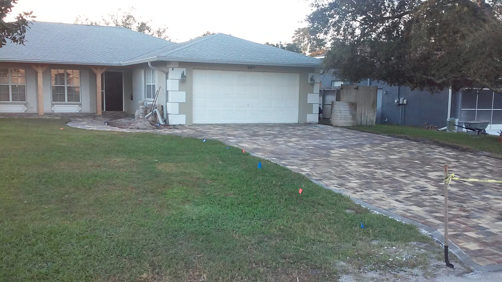 This is an example of a traditional front yard driveway in Tampa with concrete pavers.