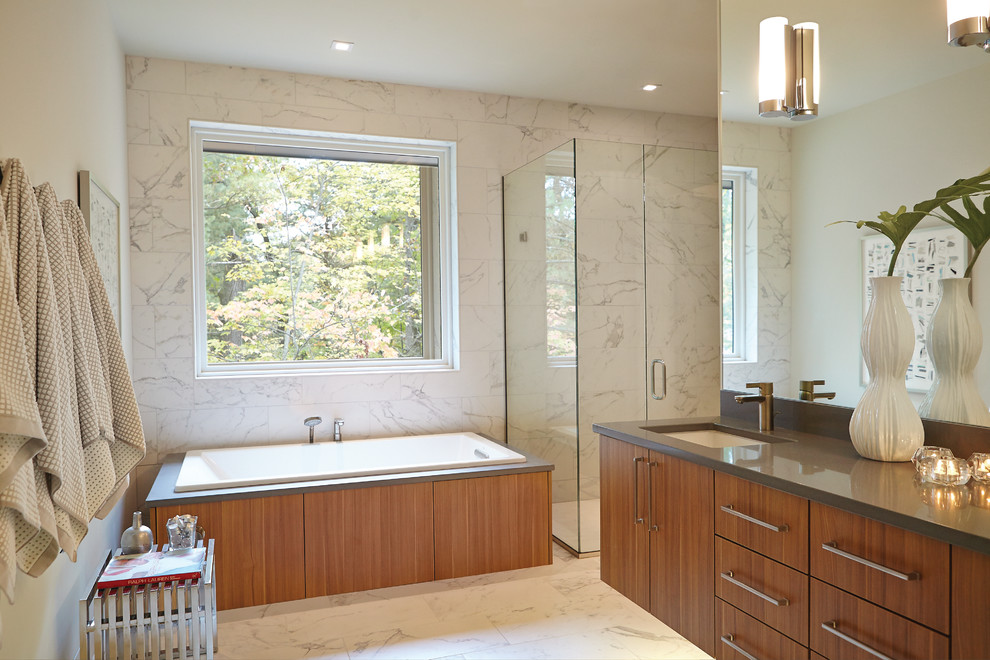 Midcentury bathroom in Grand Rapids with an undermount sink, flat-panel cabinets, medium wood cabinets, a drop-in tub, an alcove shower, white tile and grey benchtops.