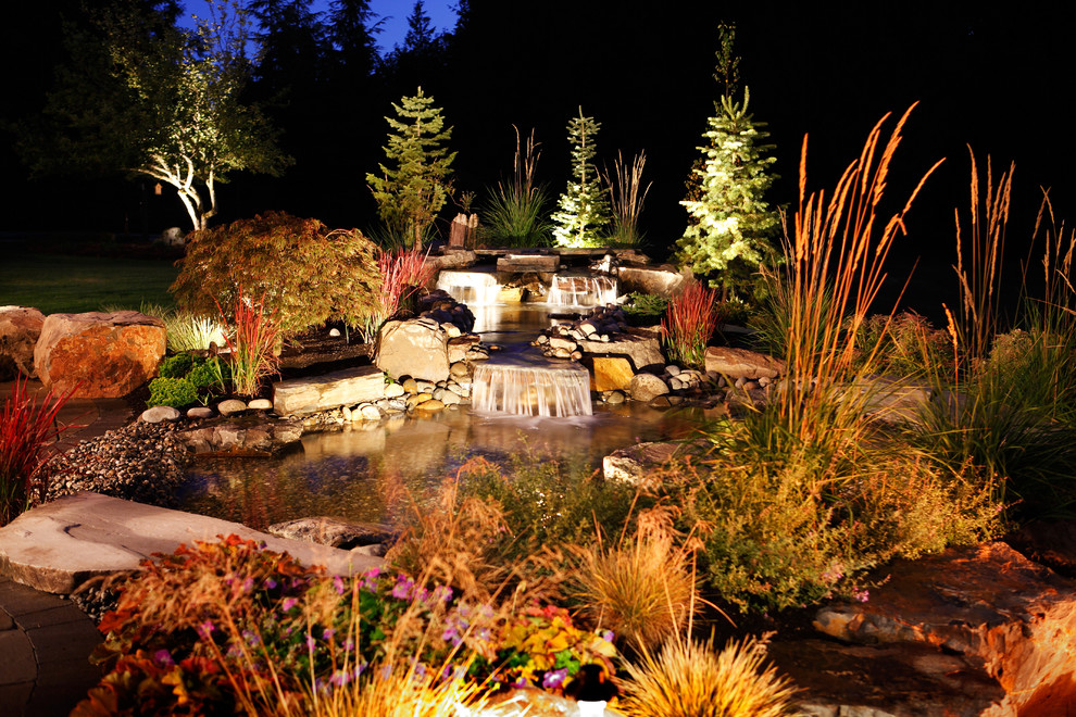 Large backyard formal garden in Seattle with a water feature.
