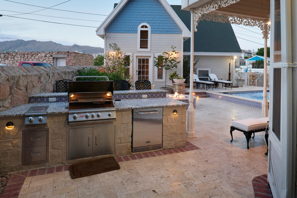 This is an example of a small traditional backyard patio in Other with an outdoor kitchen, natural stone pavers and a gazebo/cabana.