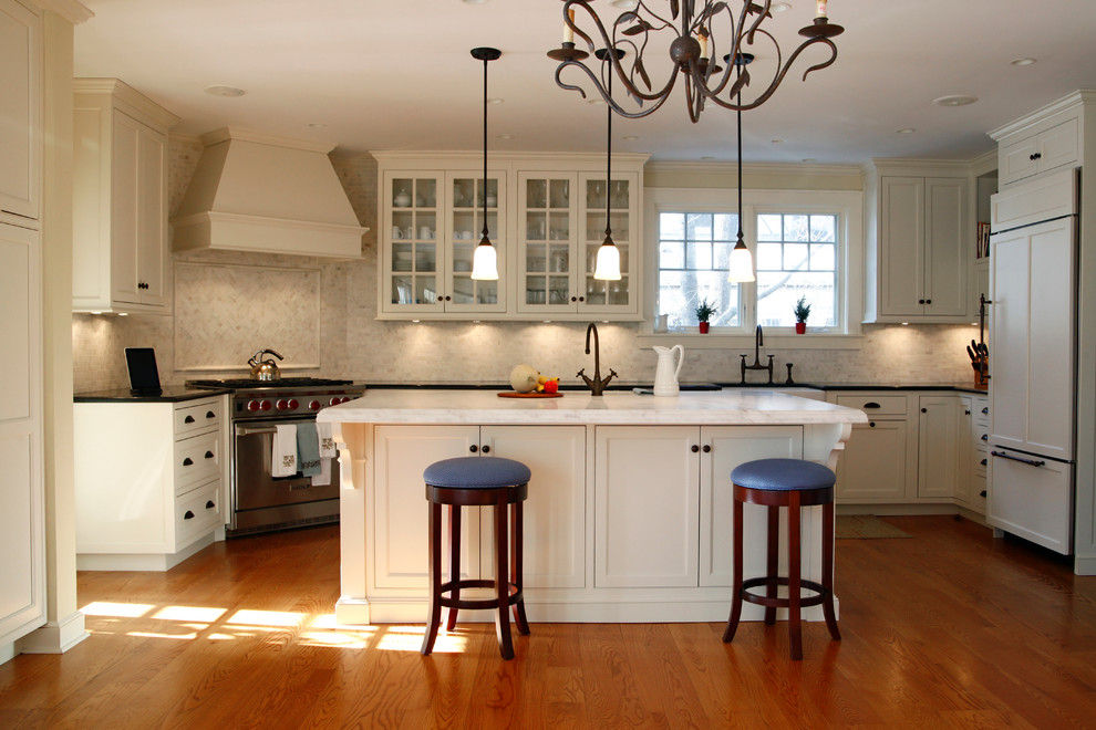 Photo of a traditional kitchen in New York with glass-front cabinets, beige cabinets and panelled appliances.