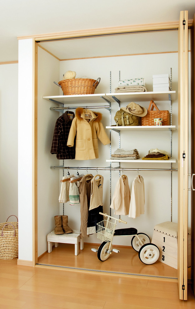 This is an example of a scandinavian built-in wardrobe in Other with light hardwood floors and beige floor.