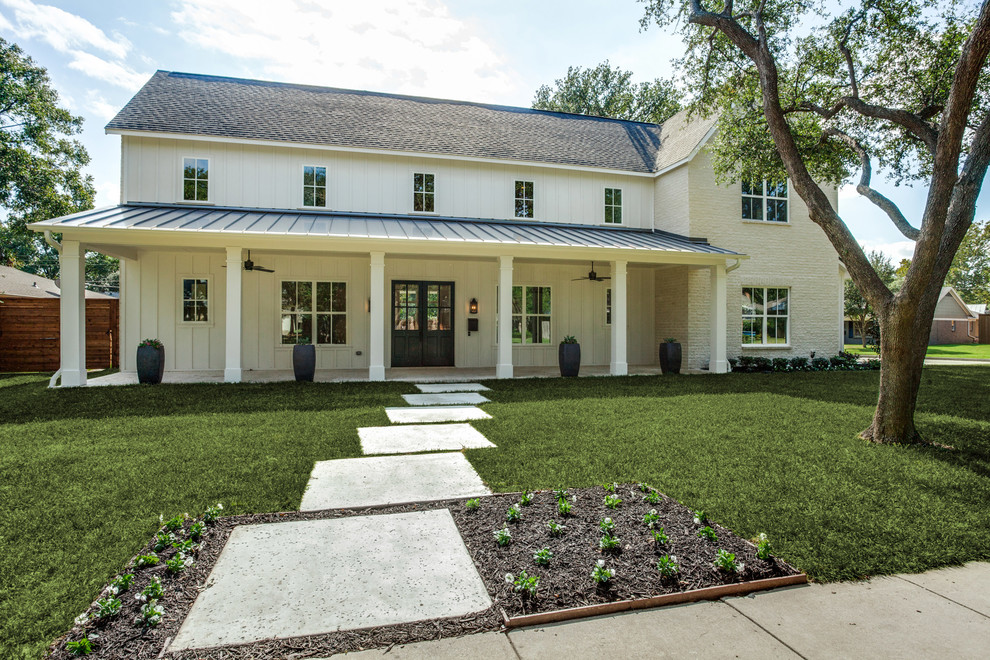 This is an example of a mid-sized country two-storey white house exterior in Dallas with concrete fiberboard siding, a gable roof and a metal roof.